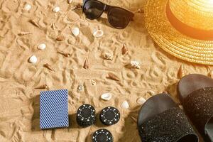 Strandpoker. Chips und Karten auf das Sand. um das Muscheln, Sonnenbrille und Flip Flops. oben Aussicht foto