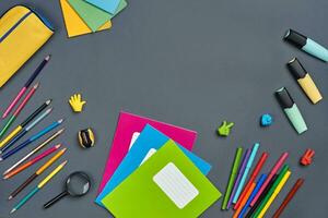 eben legen Foto von Arbeitsplatz Schreibtisch mit Schule Zubehör oder Büro liefert auf grau Hintergrund.