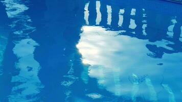 rein Blau Wasser im das Schwimmbad mit Licht Reflexionen von ein Mädchen Silhouette im sonnig Tag. Zypern. foto