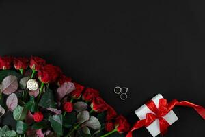 rot Rosen, Ring und Geschenk Box auf schwarz Hintergrund foto