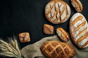 Bäckerei - - Gold rustikal knusprig Brote von Brot und Gebäck auf schwarz Tafel Hintergrund. foto