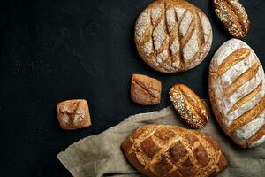 Bäckerei - - Gold rustikal knusprig Brote von Brot und Gebäck auf schwarz Tafel Hintergrund. foto