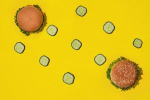 zwei lecker frisch ungesund Hamburger mit Ketchup und Gemüse auf Gelb beschwingt hell Hintergrund. oben Aussicht mit Kopieren Raum. foto