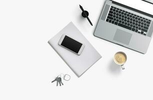 Büro Schreibtisch Tabelle mit Laptop Computer, Smartphone mit schwarz Bildschirm Über ein Notizbuch und Tasse von Kaffee. oben Sicht. foto