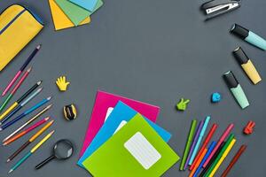 eben legen Foto von Arbeitsplatz Schreibtisch mit Schule Zubehör oder Büro liefert auf grau Hintergrund.