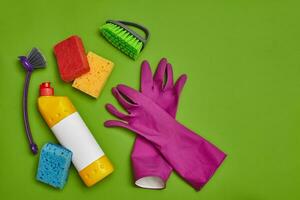 Waschmittel und Reinigung Zubehör auf ein Grün Hintergrund. Hauswirtschaft Konzept. foto
