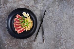 gebratene Thunfischstücke mit Kenoa und Bohnen in einem Teller