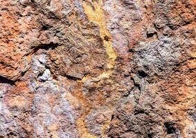 ein schließen oben von ein Felsen Mauer mit etwas Orange Farbe foto