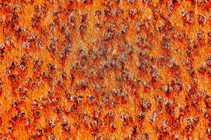 ein Orange Metall Oberfläche mit viele klein Löcher foto