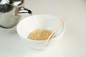 Instant-Nudeln werden schnell gekocht, indem heißes Wasser in eine Schüssel gegossen wird. foto