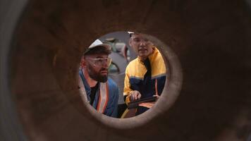 ein Mannschaft von jung Männer Arbeiten im ein Warenhaus Speicherung Rollen von Metall Blätter. inspizieren das Metall Blatt Rollen gelagert im das Warenhaus zu Sein importiert auf zu das Metall Blatt Produktion Linie. foto