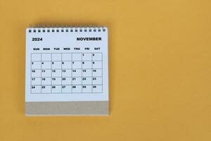 November 2024 Schreibtisch Kalender auf Gelb Hintergrund. direkt über. eben legen. foto