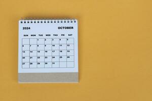 Oktober 2024 Schreibtisch Kalender auf Gelb Hintergrund. direkt über. eben legen. foto