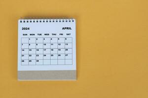 April 2024 Schreibtisch Kalender auf Gelb Hintergrund. direkt über. eben legen. foto