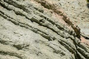 ein Person ist Stehen auf ein Felsen im das Mitte von ein Cliff foto