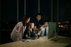 Gruppe von Geschäft Menschen Arbeiten im Büro beim Nacht. Geschäft Konzept. foto
