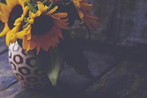 Nahaufnahme von gelben Blumen auf einem alten Holztisch