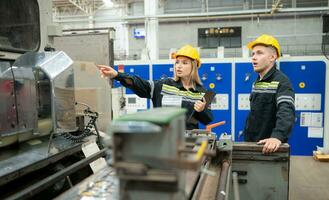 beide von Ingenieur Arbeitskräfte Arbeiten auf ein Maschine im ein Fabrik. industriell Hintergrund foto