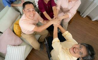 oben Aussicht von asiatisch Senior Familie halten Hände zusammen im Leben Zimmer beim Zuhause foto