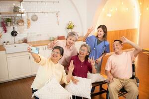 Gruppe von asiatisch Senior und Pflegekraft haben Spaß mit Selfie im das Pflege- heim. foto