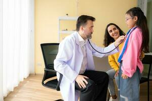 Arzt mit Stethoskop Prüfung Kind geduldig im Krankenhaus. Gesundheitswesen und medizinisch Konzept. foto