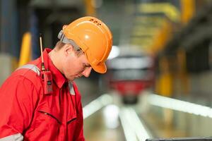 Bild von Ingenieur mit Reparatur Werkzeuge von das elektrisch Zug Industrie Dort ist ein elektrisch Zug im das Zug Reparatur Fabrik wie das Hintergrund Bild. foto