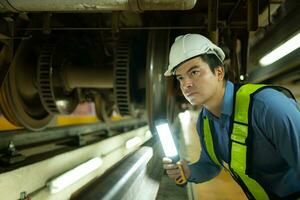 Ingenieure zum elektrisch Züge nach Erkennen Schwierigkeiten mit das elektrisch Züge Maschinen verwenden Suchscheinwerfer zu Lokalisieren und prüfen beschädigt Abschnitte. im das elektrisch Zug Reparatur Geschäft foto