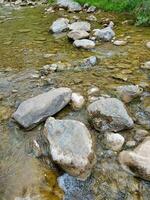 Felsen im ein Fluss mit Wasser fließend Über Sie foto