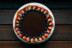 runder Schokokuchen mit frischen Beeren foto