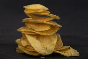 Chips gestapelt im ein rutschen auf ein grau Hintergrund Nahansicht. foto