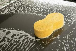Auto Reinigung und Waschen mit Gelb Schwamm und Schaum Seife foto
