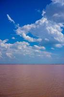 Landschaft mit Blick auf einen rosa Salzsee unter blauem Himmel mit Wolken foto