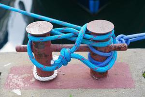 das blaue Seil, das das Boot an einer Metallstange festgebunden hat foto