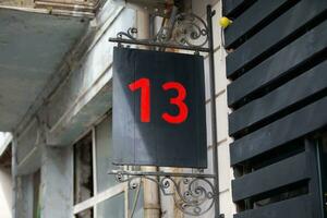 Haus Nummer dreizehn ist geschrieben im rot Farbe auf ein schwarz Hintergrund. Bäcker Dutzend. foto