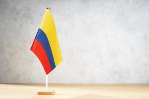 Kolumbien-Tischflagge auf weißer strukturierter Wand. Platz kopieren