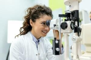 Auge Arzt mit weiblich geduldig während ein Untersuchung im modern Klinik. Augenarzt ist mit Besondere medizinisch Ausrüstung zum Auge Gesundheit Speichern und Verbesserung. foto