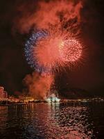 bunt Feuerwerk im das Nacht Himmel auf das direkt am Meer von alicante Spanien foto