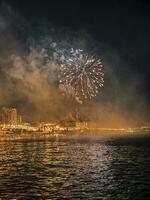 bunt Feuerwerk im das Nacht Himmel auf das direkt am Meer von alicante Spanien foto