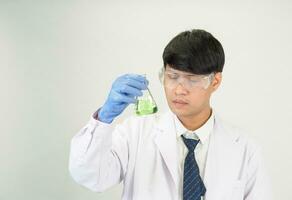Porträt asiatisch Mann Schüler Wissenschaftler oder Arzt aussehen Hand halten Reagens Mischen Labor im Wissenschaft Forschung Labor mit Prüfung Röhren von verschiedene Größe im Labor Chemie Labor Weiß Hintergrund foto