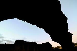 ein Silhouette von ein Felsen Formation foto