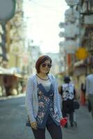 asiatisch Frau zahnig lächelnd Gesicht Stehen im Dotonbori Straße einer von die meisten Beliebt Reisen Ziel im Osaka Japan foto