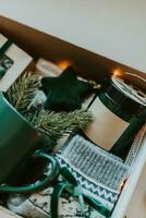 Nahansicht von Weihnachten Geschenk Kasten. gemütlich Becher zum Kaffee, warm grau Socken, Aroma Kerze im Krug. foto