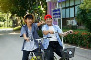 asiatisch Junge und freunde Radfahren zusammen auf das Straße um Schule auf Urlaub. es ist ein Platz mit schön Natur, gut Wetter, und ist ein Platz zum ausüben zum Menschen im das Gemeinschaft. foto