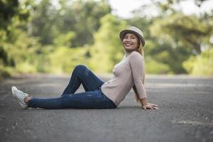 schöne junge Frau, die auf der Straße im Park liegt. foto