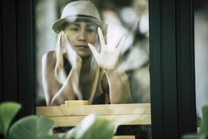 schönes Mädchen, das traurig am Fenster im Café sitzt foto