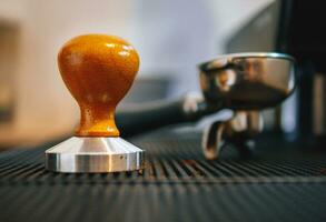 Ausrüstung im ein Kaffee Geschäft von Barista Kaffee Werkzeug Kaffee manipulieren und ein Siebträger auf Zähler im ein Cafe foto