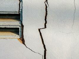 Risse im das Zement Mauer Weiß Zement von Gebäude beschädigt durch Erdbeben foto