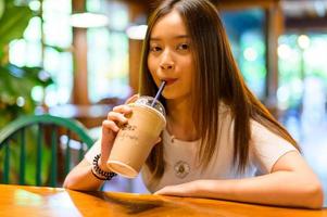 schöne Frau sitzt auf einem Stuhl in einem Café foto