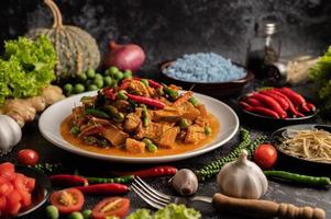 rotes Curry mit Schweinefleisch in einem weißen Teller foto