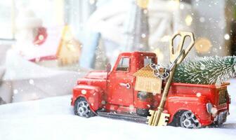 Rotes Retro-Auto mit einem Weihnachtsbaum schmückt mit dem Hausschlüssel im Pickup-Truck zu Weihnachten. Hauskauf, Umzug, Hypothek, Darlehen, Immobilien, Feststimmung, Neujahr foto